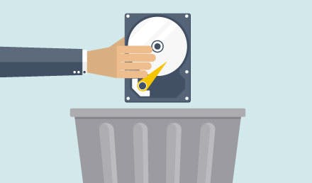 Händer håller en hårddisk över en soptunna.