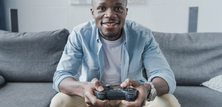 A PlayStation gamer on a sofa.